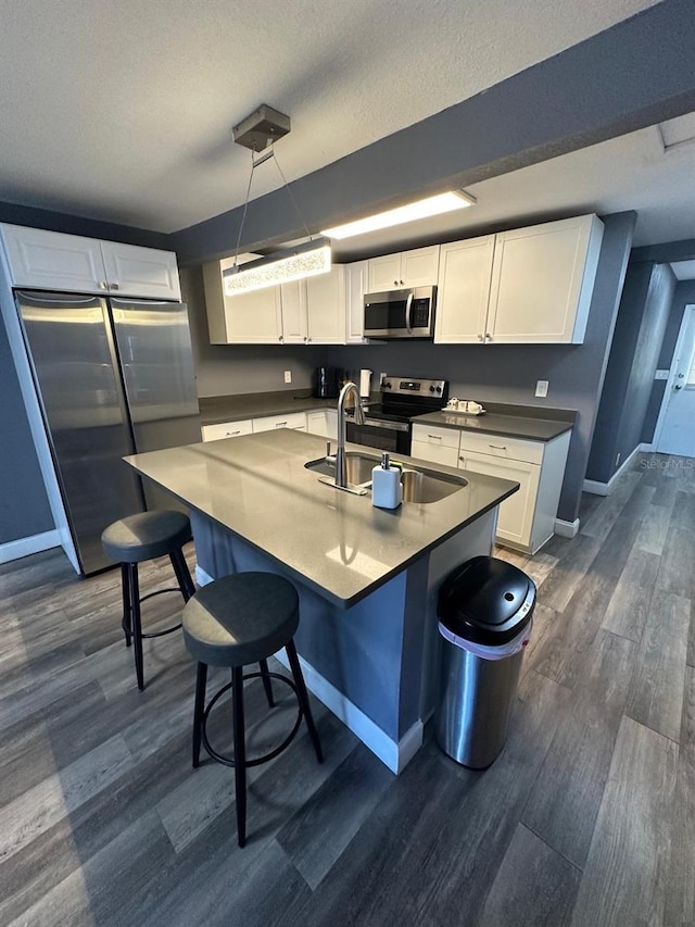 8702 El Portal Dr, Tampa, FL 33604 - kitchen with appliances with stainless steel finishes, baseboards, dark wood-style floors, and a textured ceiling