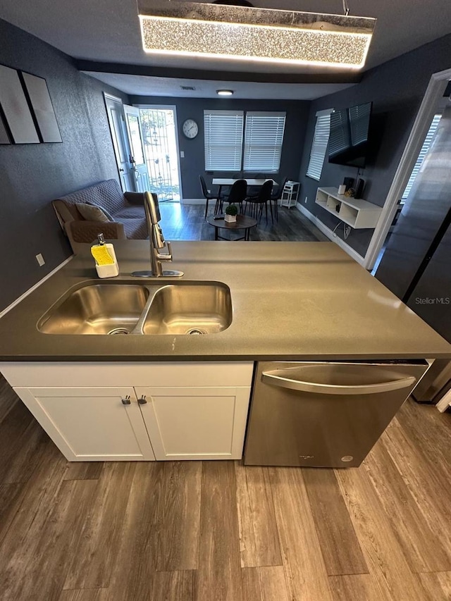 8702 El Portal Dr, Tampa, FL 33604 - kitchen with a sink, wood finished floors, white cabinetry, dishwasher, and a warming drawer
