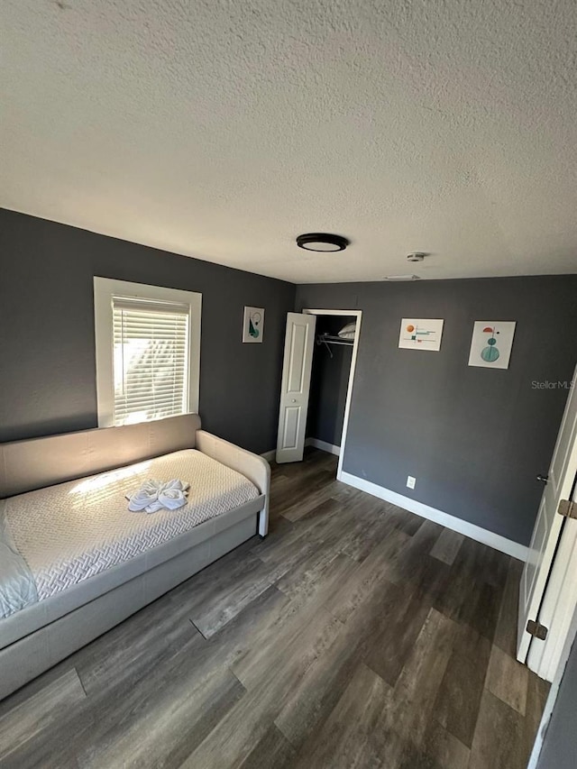8702 El Portal Dr, Tampa, FL 33604 - bedroom with a textured ceiling, wood finished floors, baseboards, and a closet