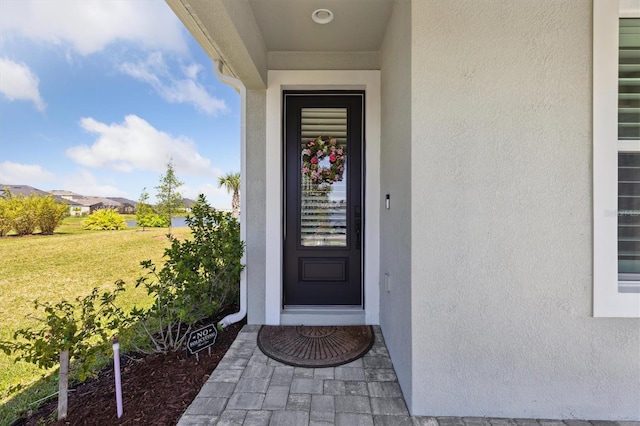 2476 Kamin Dr, Melbourne, FL 32940 - view of exterior entry with stucco siding and a yard
