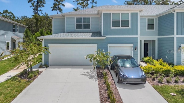 view of front of home featuring a shingled roof, board and batten siding, an attached garage, and concrete driveway