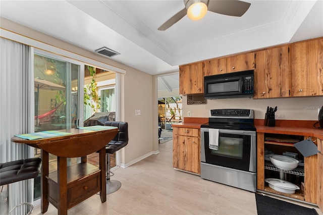 5053 Maui Cir Unit 14, Orlando, FL 32808 - kitchen featuring visible vents, black microwave, brown cabinets, stainless steel range with electric cooktop, and light wood-style flooring