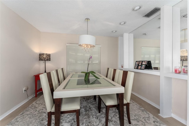 5053 Maui Cir Unit 14, Orlando, FL 32808 - dining space with a textured ceiling, baseboards, visible vents, and wood finished floors
