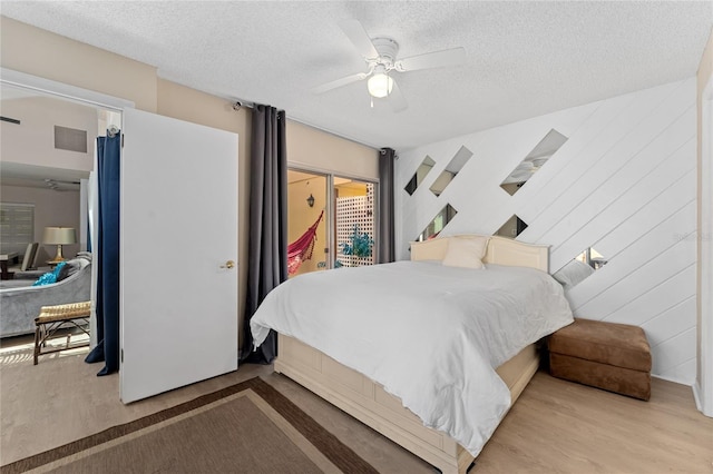 5053 Maui Cir Unit 14, Orlando, FL 32808 - bedroom with a textured ceiling, access to exterior, a ceiling fan, wood finished floors, and visible vents