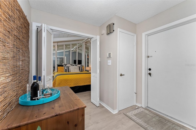 5053 Maui Cir Unit 14, Orlando, FL 32808 - entryway featuring baseboards, a textured ceiling, and light wood finished floors