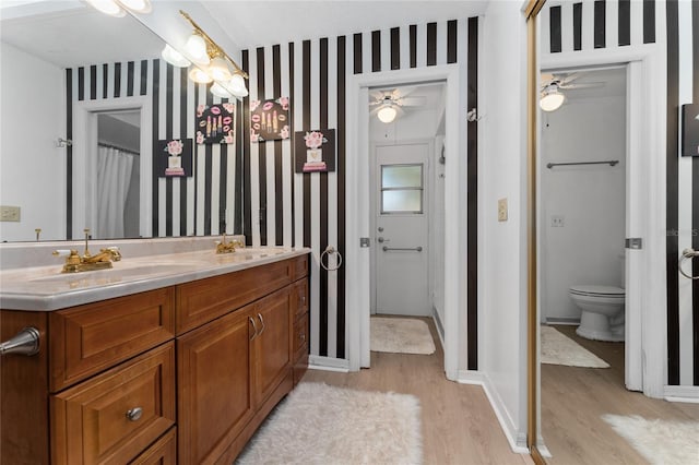 5053 Maui Cir Unit 14, Orlando, FL 32808 - bathroom with a ceiling fan, wallpapered walls, a sink, and wood finished floors