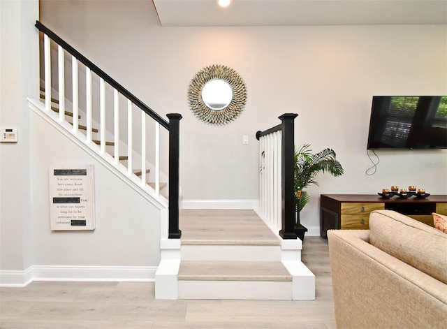 stairway featuring baseboards, recessed lighting, and wood finished floors