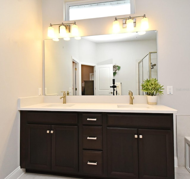 bathroom with a sink, a stall shower, and double vanity