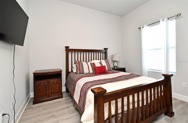 bedroom with baseboards and wood finished floors