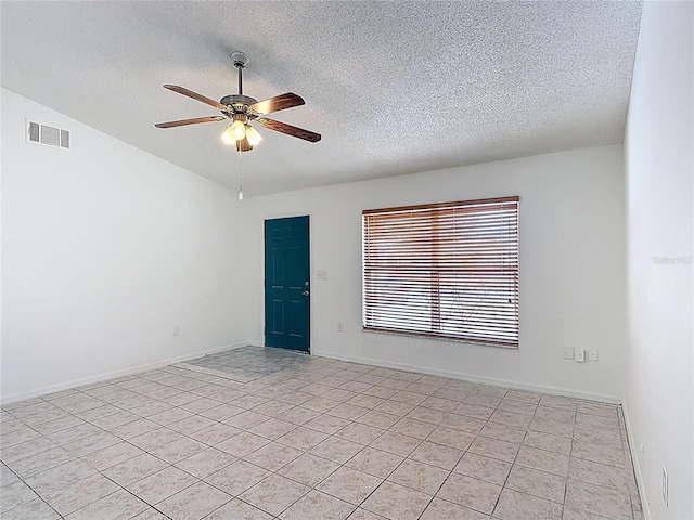 spare room featuring a ceiling fan, a textured ceiling, visible vents, light tile patterned floors, and lofted ceiling