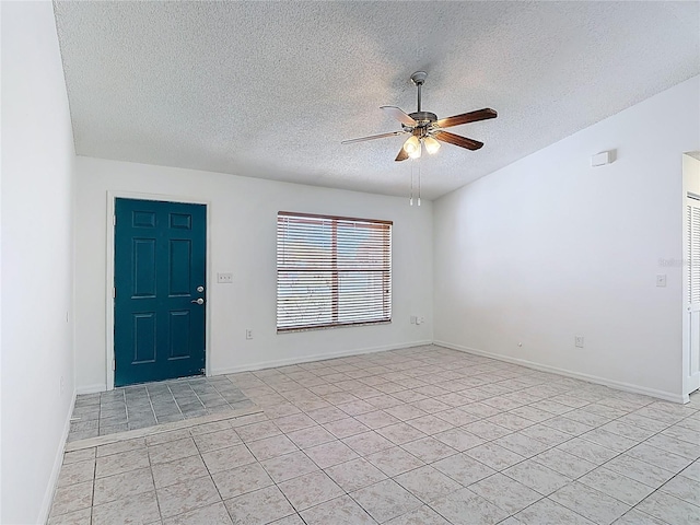 empty room featuring a ceiling fan, a textured ceiling, and light tile patterned floors