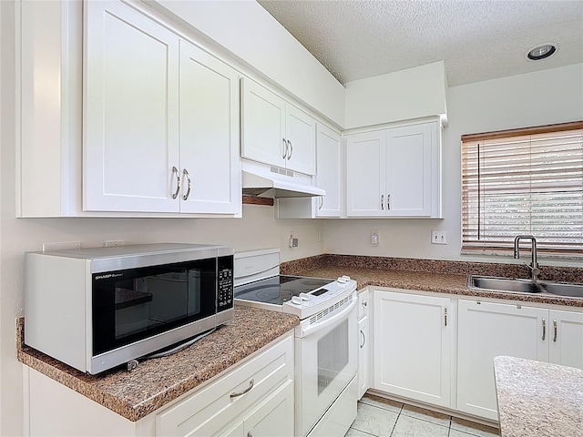 kitchen with electric range, a sink, a textured ceiling, stainless steel microwave, and under cabinet range hood