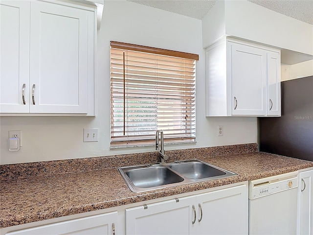 kitchen featuring dark countertops, white cabinetry, a textured ceiling, a sink, and dishwasher