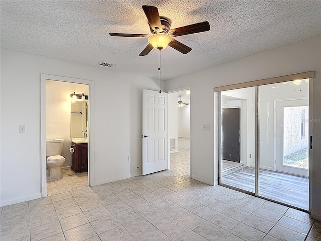 unfurnished bedroom with light tile patterned floors, a textured ceiling, and visible vents