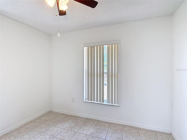 spare room featuring baseboards, a textured ceiling, ceiling fan, and light tile patterned floors