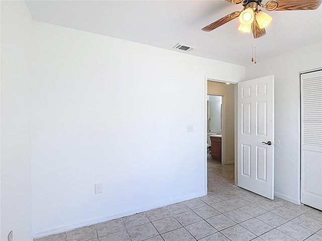unfurnished bedroom with baseboards, visible vents, light tile patterned floors, and a closet