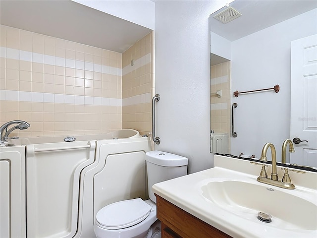 full bathroom featuring a bathing tub, vanity, toilet, and visible vents