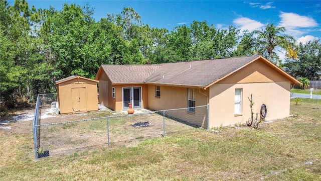 rear view of property featuring a fenced backyard, stucco siding, french doors, a lawn, and a storage shed
