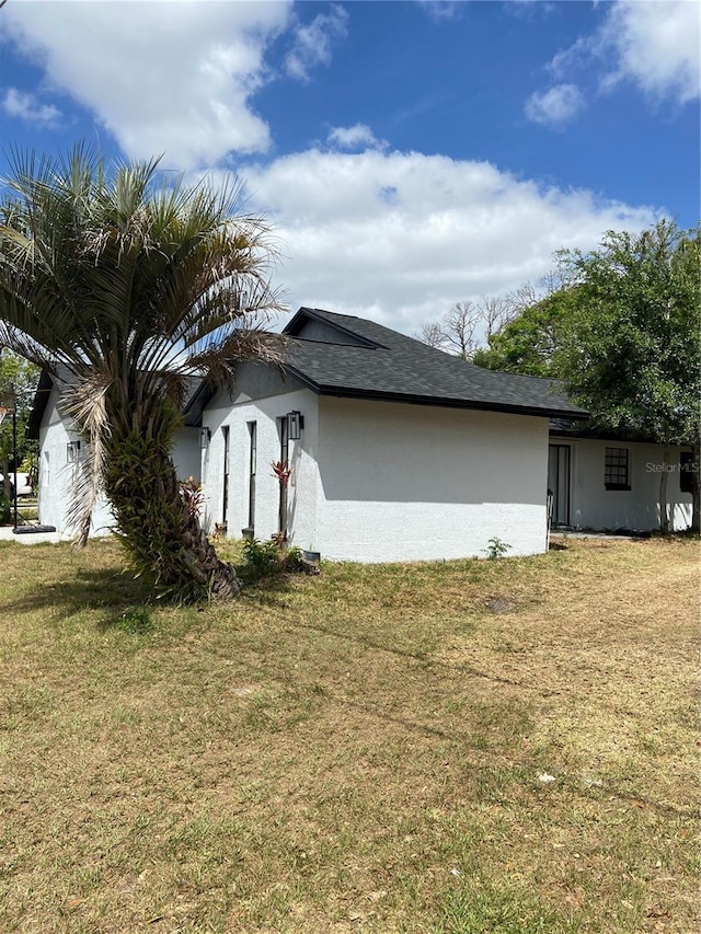225 Ronnie Cir, Orlando, FL 32811 - view of property exterior with a yard and stucco siding
