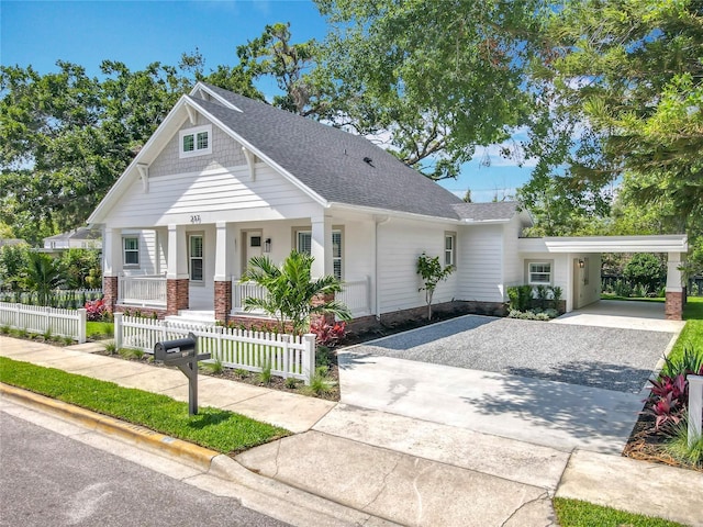 view of front of house with a porch, driveway, a shingled roof, and a fenced front yard