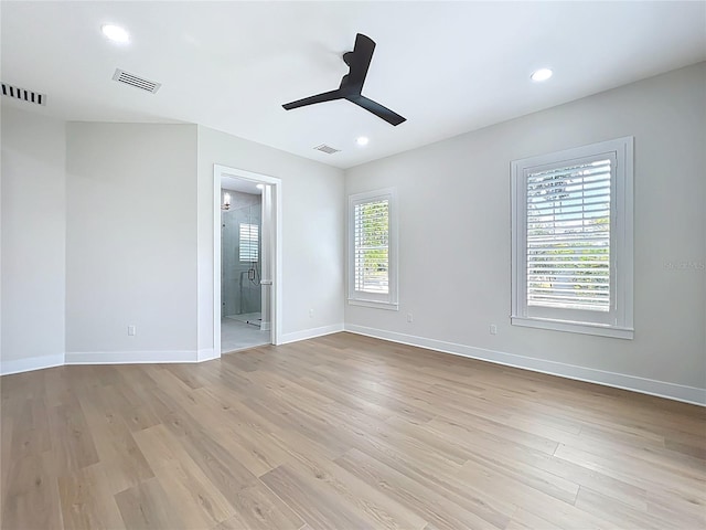 spare room with a ceiling fan, light wood-style flooring, and visible vents