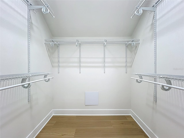 walk in closet with wood finished floors