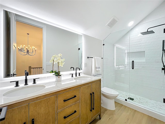 full bath featuring visible vents, a sink, wood finished floors, and vaulted ceiling