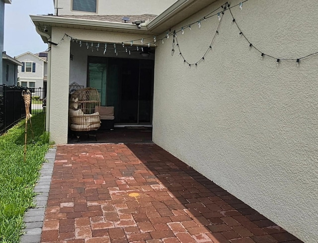 exterior space featuring a patio, fence, and stucco siding