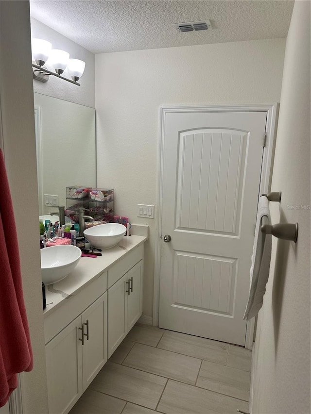 15929 Moonlight Bay St, Winter Garden, FL 34787 - bathroom with double vanity, a textured ceiling, and a chandelier