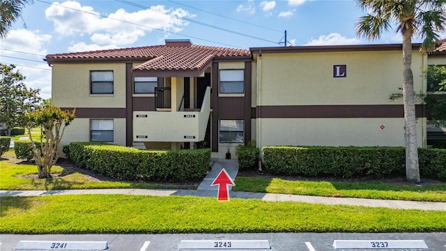 3235 Candle Ridge Dr Unit 102, Orlando, FL 32822 - view of front of home featuring a tiled roof, uncovered parking, and stucco siding