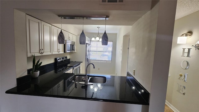 3235 Candle Ridge Dr Unit 102, Orlando, FL 32822 - kitchen with white cabinets, dark countertops, a sink, stainless steel appliances, and visible vents