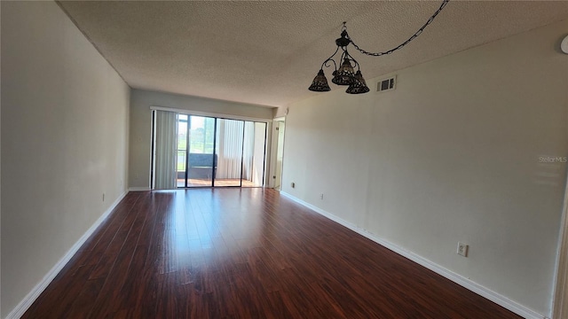 3235 Candle Ridge Dr Unit 102, Orlando, FL 32822 - spare room featuring baseboards, a textured ceiling, dark wood finished floors, and visible vents