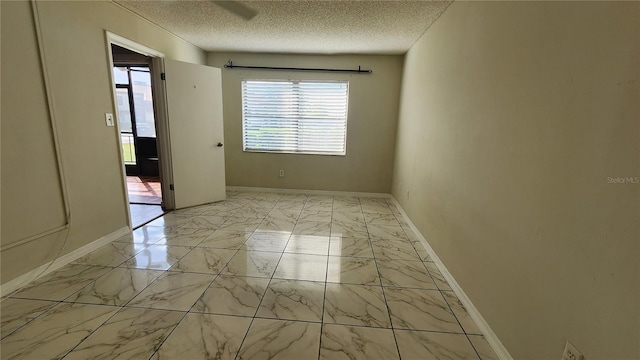 3235 Candle Ridge Dr Unit 102, Orlando, FL 32822 - empty room featuring baseboards, a textured ceiling, marble finish floor, and a healthy amount of sunlight