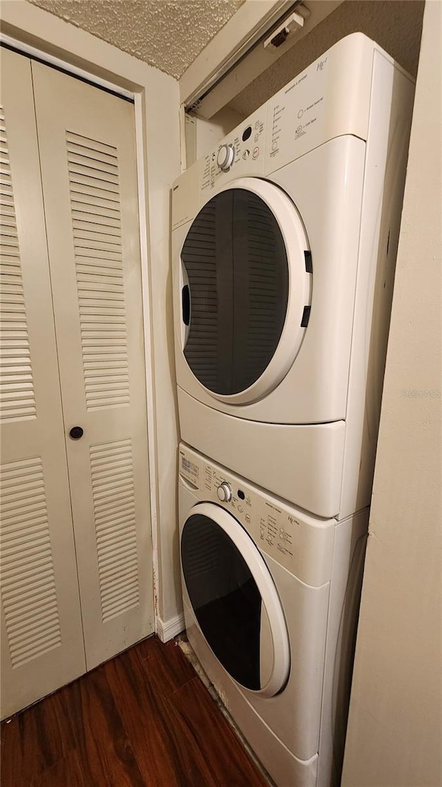 3235 Candle Ridge Dr Unit 102, Orlando, FL 32822 - laundry room with dark wood-style flooring, a textured ceiling, and stacked washer and clothes dryer