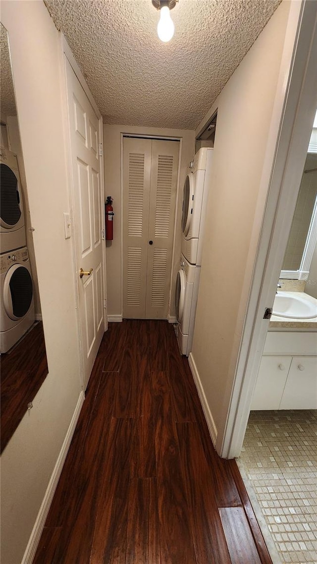 3235 Candle Ridge Dr Unit 102, Orlando, FL 32822 - hall featuring baseboards, a sink, wood finished floors, and stacked washer and clothes dryer