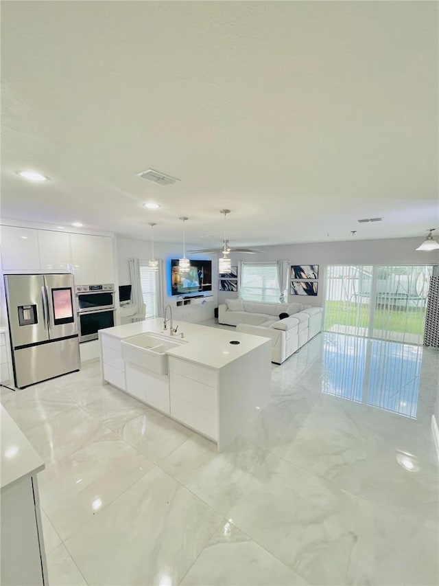 247 Whispering Pines Way, Davenport, FL 33837 - kitchen with stainless steel appliances, modern cabinets, a sink, white cabinets, and open floor plan