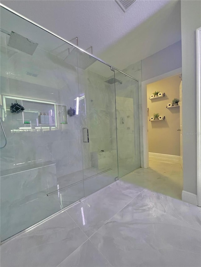 247 Whispering Pines Way, Davenport, FL 33837 - bathroom featuring a marble finish shower, baseboards, and marble look tiles