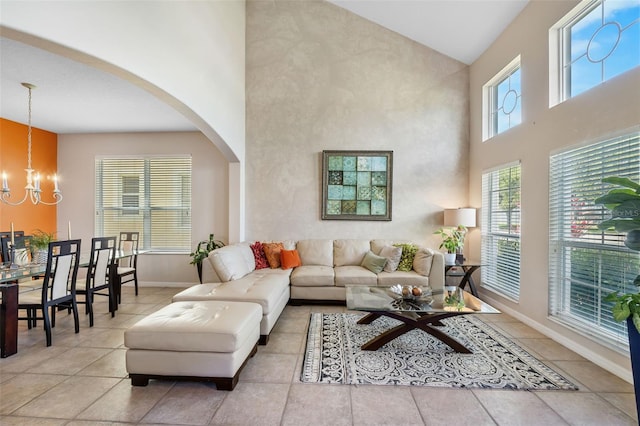 5321 Los Palma Vista Dr, Orlando, FL 32837 - living room featuring a notable chandelier, arched walkways, high vaulted ceiling, tile patterned floors, and baseboards