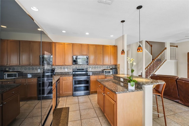 5321 Los Palma Vista Dr, Orlando, FL 32837 - kitchen with a breakfast bar area, a kitchen island, appliances with stainless steel finishes, tasteful backsplash, and open floor plan