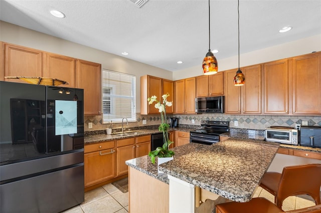 5321 Los Palma Vista Dr, Orlando, FL 32837 - kitchen featuring decorative backsplash, a breakfast bar area, a sink, appliances with stainless steel finishes, and decorative light fixtures