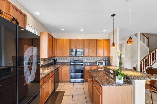 5321 Los Palma Vista Dr, Orlando, FL 32837 - kitchen with a kitchen island, tasteful backsplash, dark stone counters, a breakfast bar, and stainless steel appliances