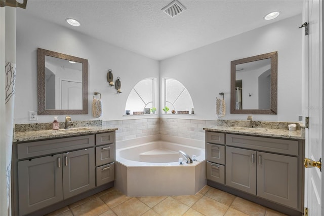 5321 Los Palma Vista Dr, Orlando, FL 32837 - full bathroom with visible vents, two vanities, a sink, and a garden tub