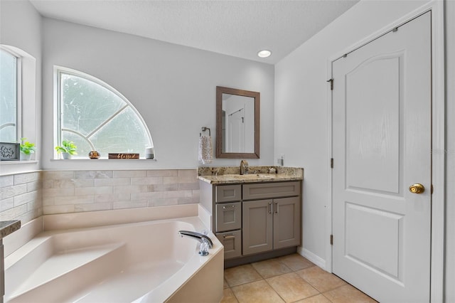 5321 Los Palma Vista Dr, Orlando, FL 32837 - full bathroom with vanity, tile patterned flooring, a garden tub, and a textured ceiling