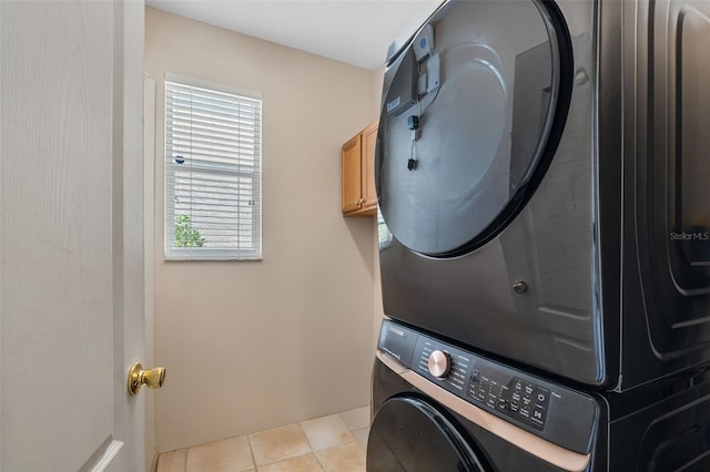 5321 Los Palma Vista Dr, Orlando, FL 32837 - laundry area with tile patterned flooring, cabinet space, and stacked washer / dryer