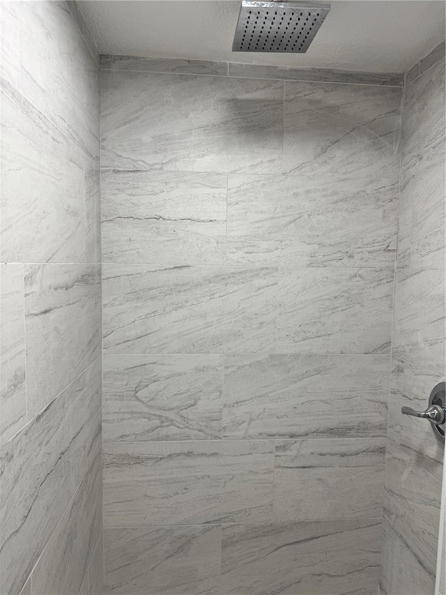 full bathroom featuring tiled shower