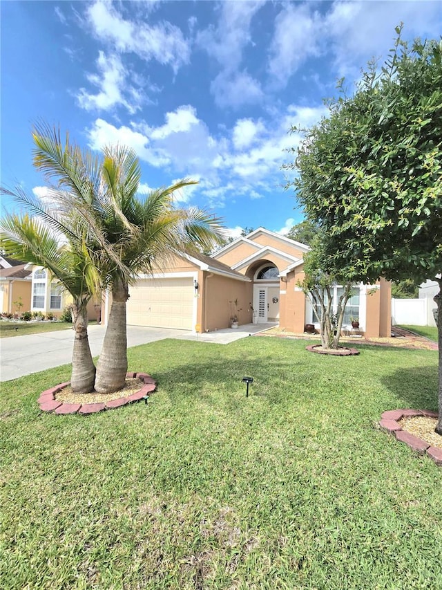 2346 Lily Pad Ln, Kissimmee, FL 34743 - view of front of home with fence, an attached garage, a front lawn, stucco siding, and concrete driveway