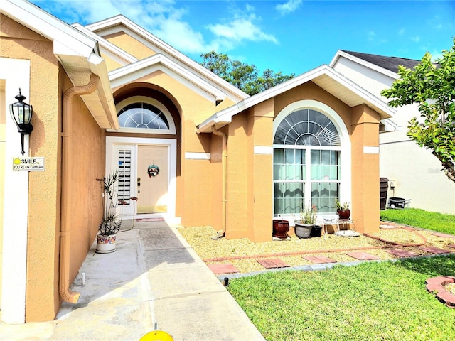 2346 Lily Pad Ln, Kissimmee, FL 34743 - property entrance with a lawn and stucco siding