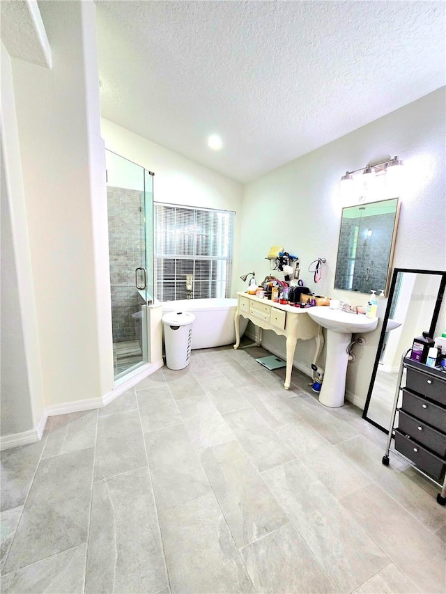 2346 Lily Pad Ln, Kissimmee, FL 34743 - bathroom featuring a freestanding bath, tile patterned floors, a stall shower, and a textured ceiling