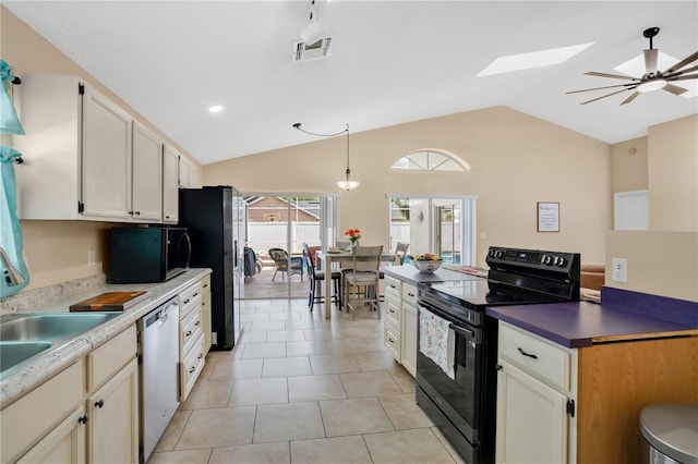 kitchen featuring ceiling fan, hanging light fixtures, black appliances, light tile patterned floors, and lofted ceiling with skylight
