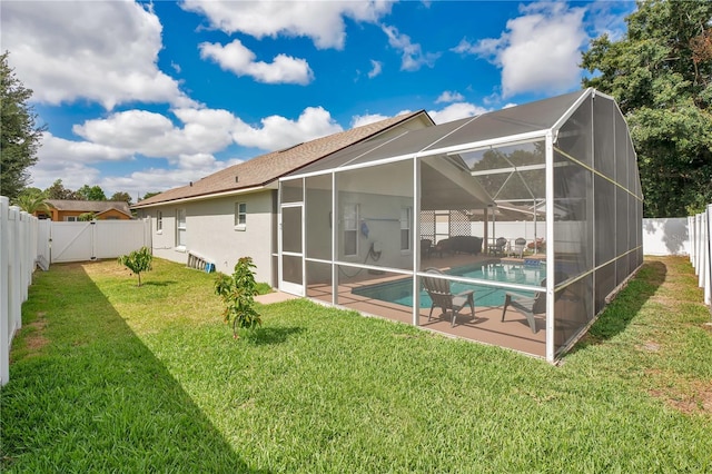 rear view of house with a fenced backyard, a fenced in pool, a gate, a patio area, and a lawn